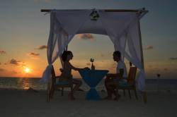 pár večeří na Maledivách při západu slunce