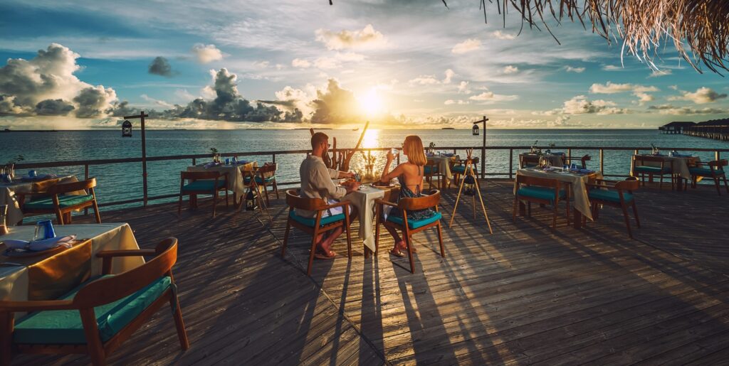 pár večeří při západu slunce na Maledivách