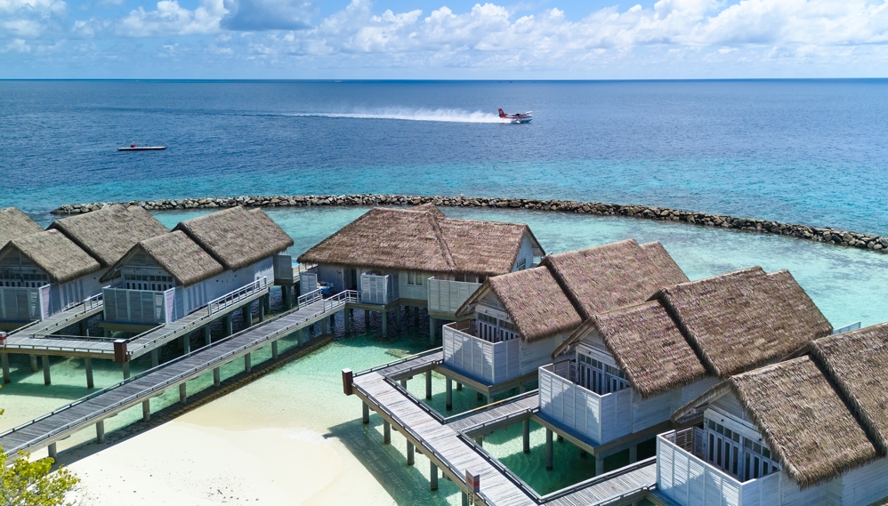 vodní vily na Maledivách a přistávající hydroplán