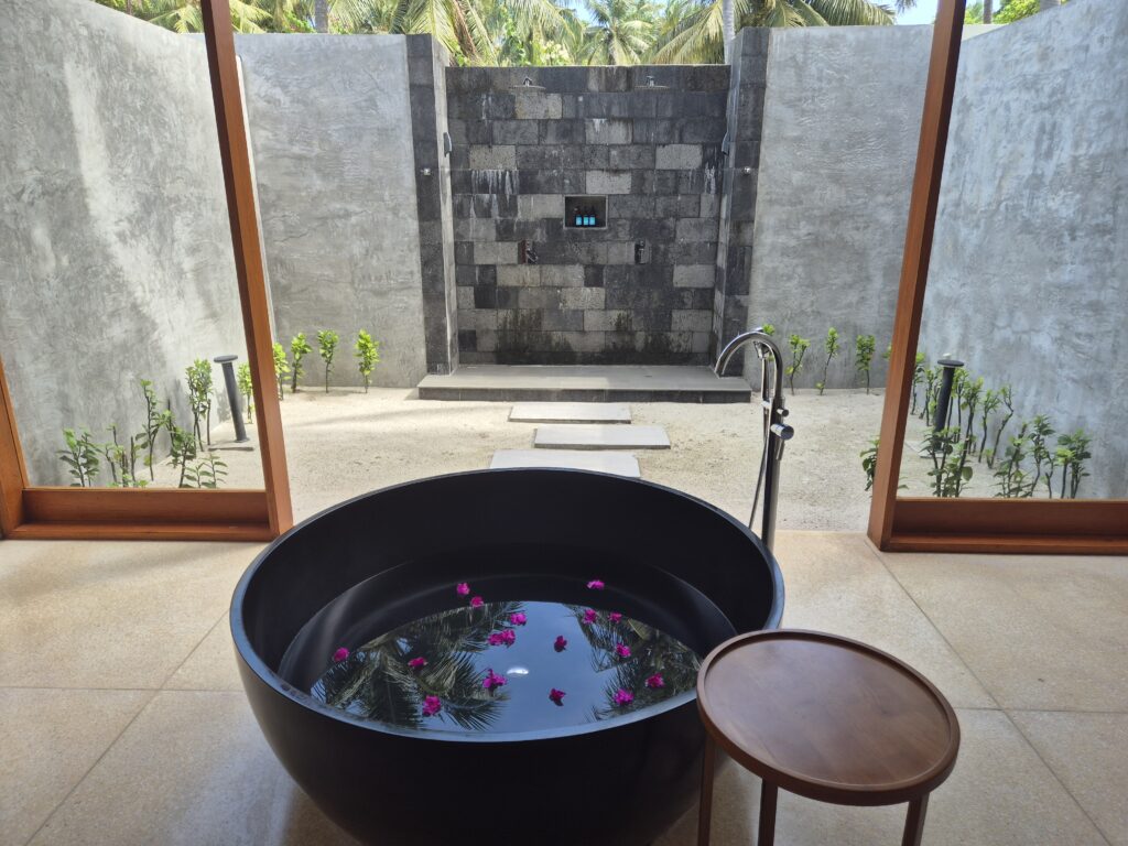 otevřená koupelna s vanou v plážové vile s bazénem